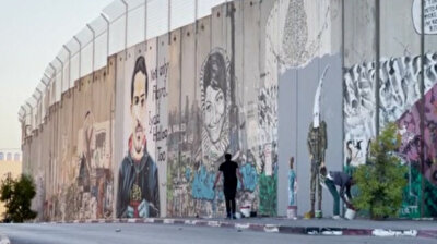 Palestinian graffiti artist paints stories on West Bank barrier