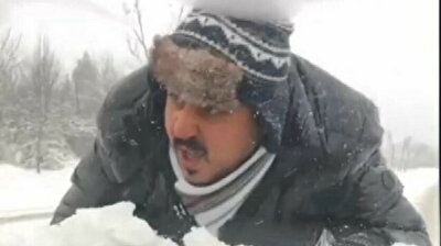 Man climbs atop vehicle to prevent tires from veering off-course in snowy weather