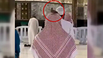 Devout pigeon sits resolutely on Muslim worshiper praying at Kaaba