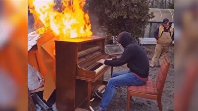 Youth plays tune on burning piano