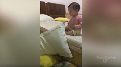 Careful baby uses pillows to get down from bed