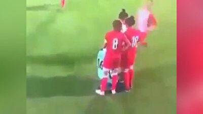 Female football players form protective circle around teammate whose headscarf fell off
