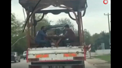 Turks play backgammon on picnic table at the back of moving truck