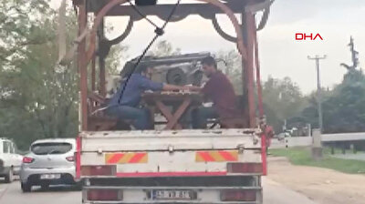 شاهد.. شخصان يستمتعان بلعب الطاولة على متن شاحنة تسير