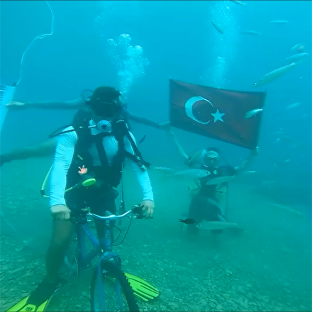 Denizin dibinde bisiklet üzerinde pankart açtılar