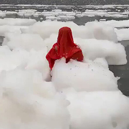 Hindistanda zehirli köpükler içindeki nehirde bir kadın dua etti