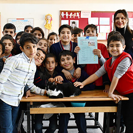 Öğrencilerin sahiplendiği sokak kedisi Hüsnü de karnesini aldı