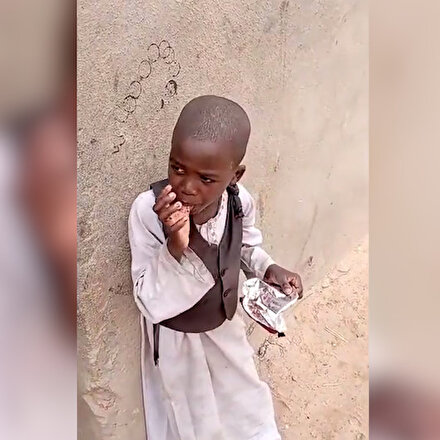 Sudanlı çocuk yere atılan kek poşetini alıp ambalajda kalan kırıntıları yiyor