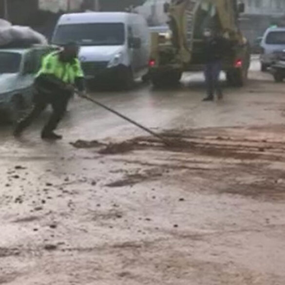 İzmir'de sel sonrası yolda biriken çamuru polis memuru böyle temizledi