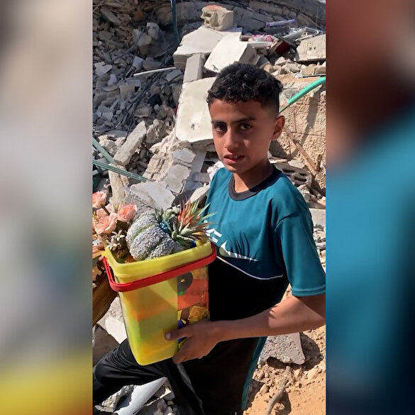 Gazze'de bir çocuk yıkılan evinin enkazından eşyalarını arıyor