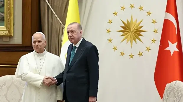 Cette photo prise et publiée par le service de presse présidentiel turc le 27 novembre 2025 montre le président turc Recep Tayyip Erdogan (à droite) serrant la main du pape Léon XIV lors d'une cérémonie officielle d'accueil au complexe présidentiel d'Ankara.