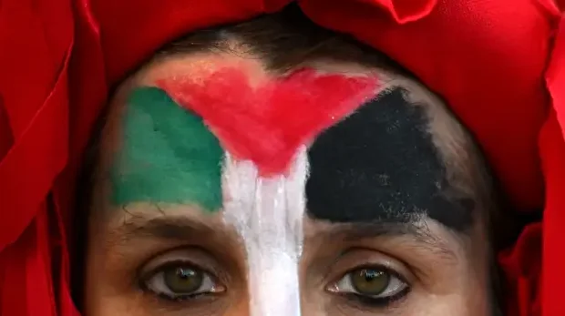 Une manifestante au visage peint aux couleurs du drapeau palestinien participe à une marche à Buenos Aires le 7 octobre 2025.