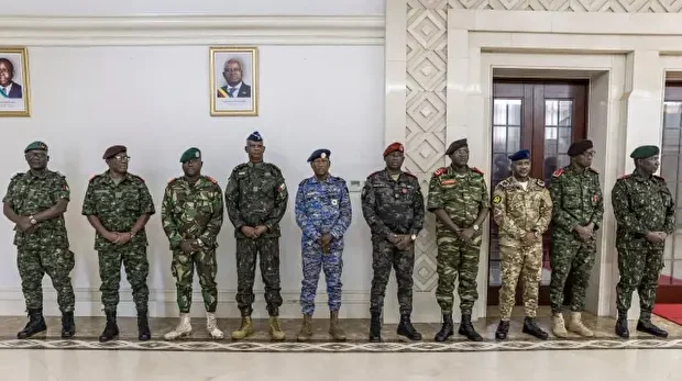 Le président du gouvernement de transition, le général Horta N'Tam (à droite), salue un officier de l'armée lors de la cérémonie de prestation de serment au palais présidentiel de Bissau, le 28 novembre 2025. Le nouveau chef militaire de la Guinée-Bissau a nommé vendredi un allié du président déchu au poste de Premier ministre, alors que les critiques internationales s'intensifiaient à l'égard du coup d'État de cette semaine. Les véritables motivations de ce putsch, le cinquième que connaît ce pays d'Afrique de l'Ouest en 45 ans, restent floues. 
