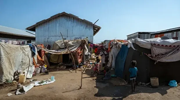De jeunes réfugiés et rapatriés se rassemblent devant des abris de fortune au centre de transit de Renk, au Soudan du Sud, le 18 novembre 2025.