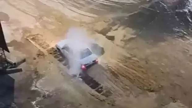 Sürücünün otomobilini yıkadığı anlar cep telefonu kamerasına yansıdı.