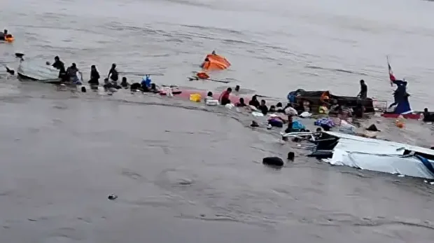 Cette photo diffusée par le COER (Centre régional des opérations d'urgence) montre des personnes autour de l'épave d'un navire impliqué dans un accident survenu dans le port d'Iparia, dans le département d'Ucayali, dans la jungle centrale du Pérou, le 1er décembre 2025.