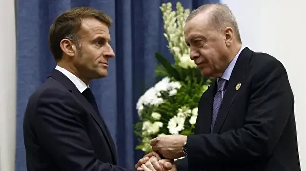 Le président français Emmanuel Macron (à gauche) serre la main du président turc Recep Tayyip Erdogan lors de leur rencontre en marge du sommet pour la paix de Charm el-Cheikh, dans la station balnéaire égyptienne de Charm el-Cheikh, sur la mer Rouge, le 13 octobre 2025.