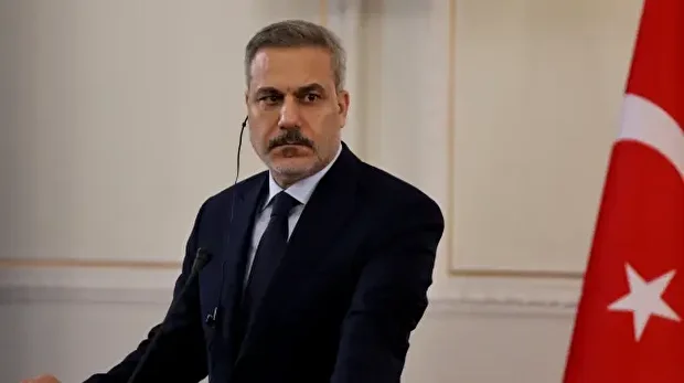 Le ministre turc des Affaires étrangères, Hakan Fidan, écoute son homologue iranien lors d'une conférence de presse conjointe, à Téhéran, le 30 novembre 2025.