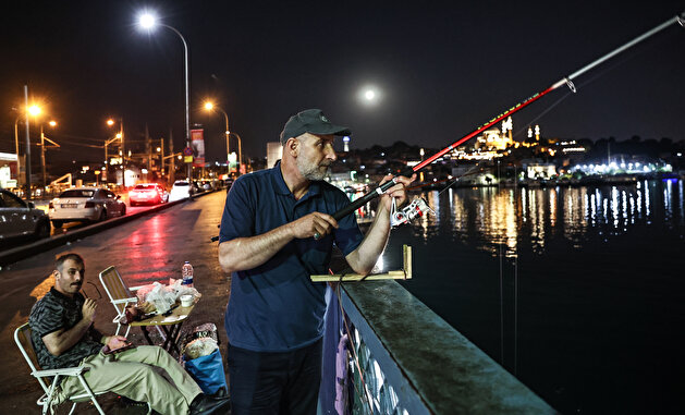 Fishermen catch fish at Galata Bridge in Istanbul