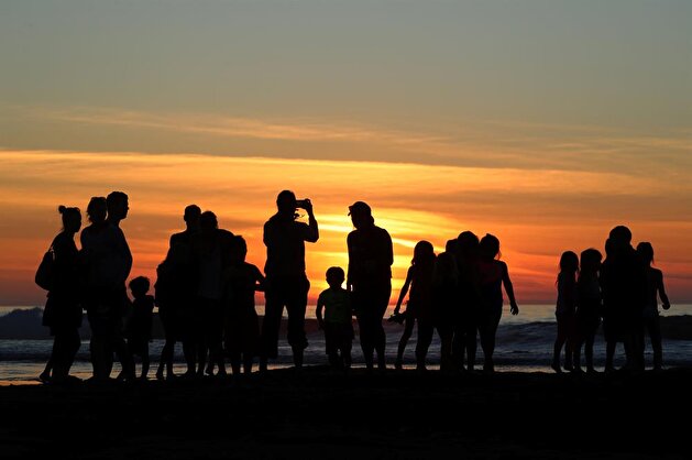 Californians enjoy sunset during low tide