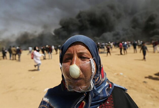 متظاهرون فلسطينيون في غزة يرتدون أقنعة مصنوعة يدوياً لحماية أنفسهم من الغاز المسيل للدموع