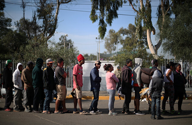 Migrants rest outside of a temporary shelter in Tijuana