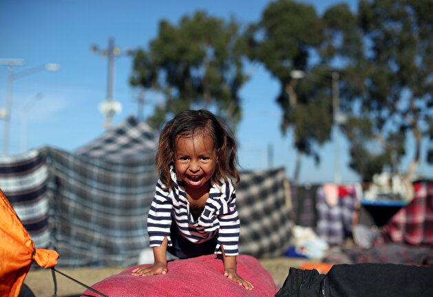 Migrants rest outside of a temporary shelter in Tijuana