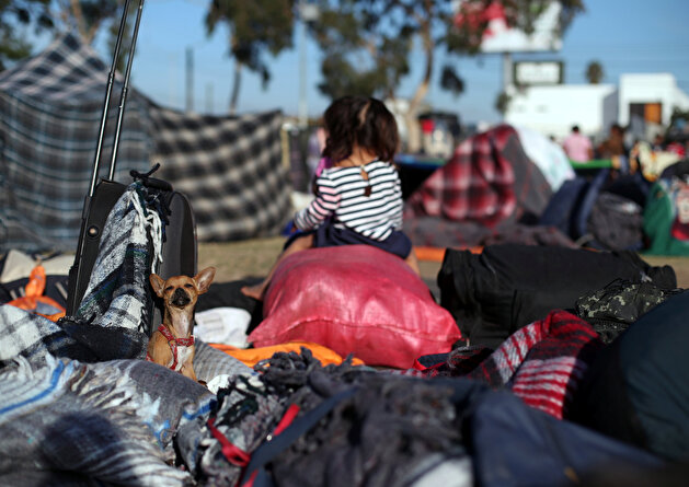Migrants rest outside of a temporary shelter in Tijuana
