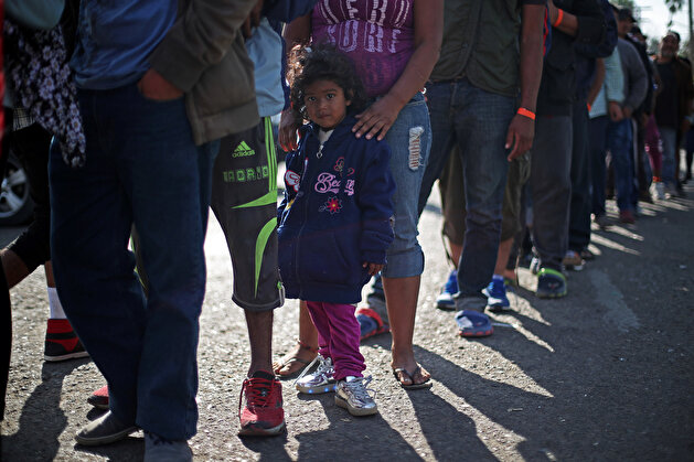 Migrants rest outside of a temporary shelter in Tijuana