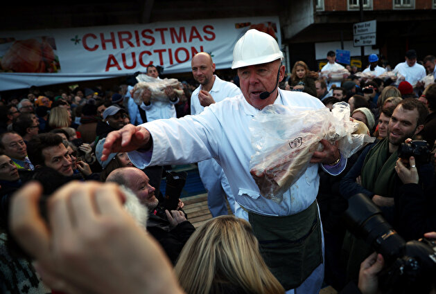 Butchers prepare to sell cuts of meat during a Christmas Eve auction in Smithfield market in London