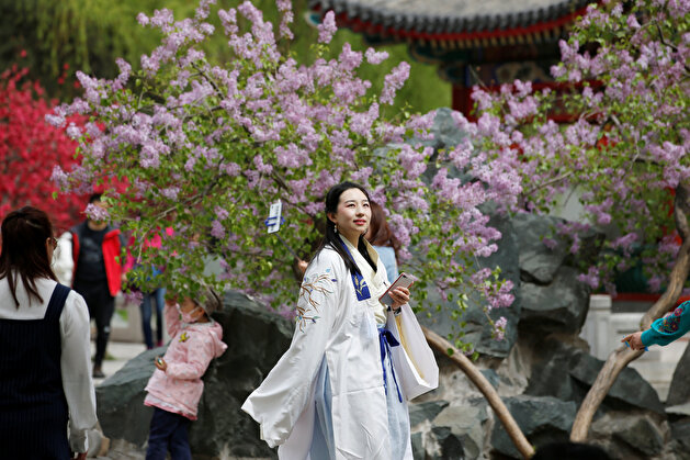 Women dressed in traditional costumes are seen during the Qingming tomb-sweeping festival in Beijing
