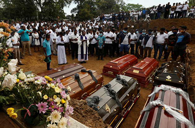 People attend in a mass funeral in Negombo