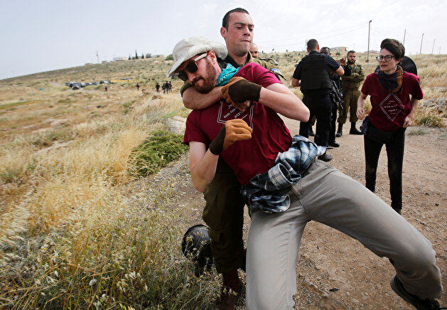 Israeli forces detain foreign activists during a protest in Yatta in the Israeli-occupied West Bank