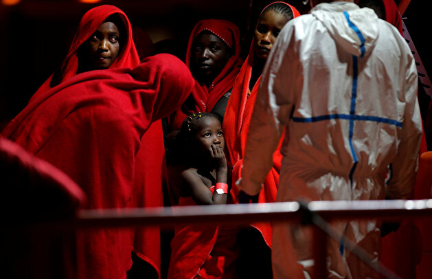 Migrants wait to disembark from a rescue boat at the port of Malaga