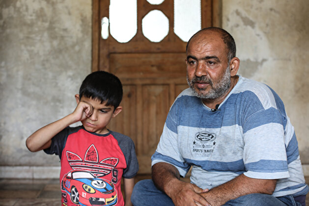 Syrian father carrying his disabled son on his back and taking him to school waits for help