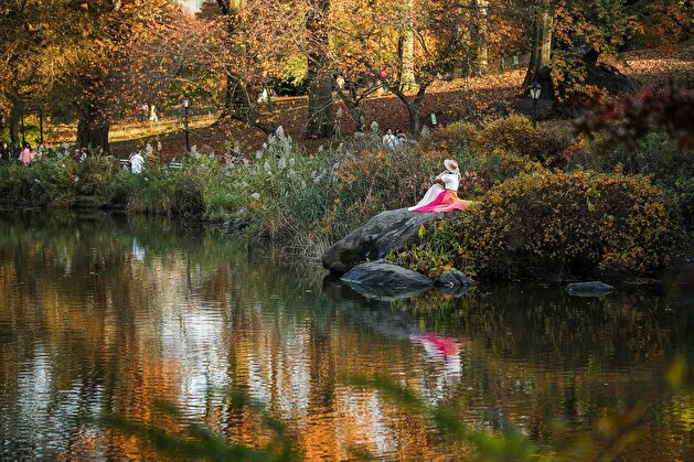 People enjoy autumn foliage at the Central Park in New York City