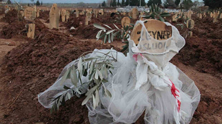 DEPREMDE ÖLEN GELİNLİK ÇAĞINDAKİ IKZILARIN MEZAR TAŞLARINA BEYAZ DUVAKLAR BAĞLANIRKEN, OKULLARI YARIM KALAN ÖĞRENCİLERİN MEZARLARINDA İSE BIRAKILAN KALEMLER YER ALDI.