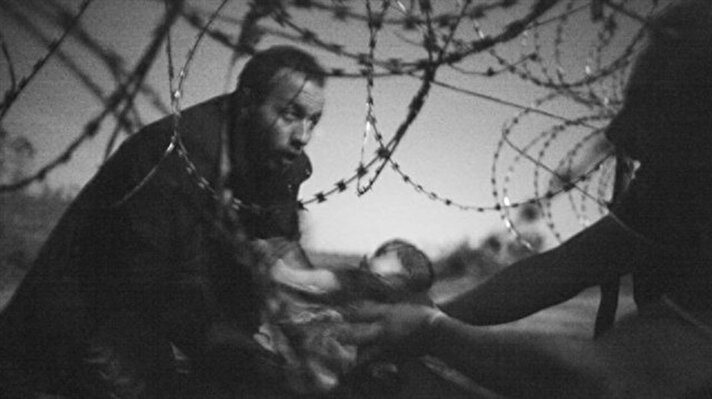 Dünya Basın Fotoğrafları Yarışması jürisi, 2015 Yılın En İyi Fotoğrafı ödülünü mülteci krizinin zorluğunu anlatan siyah-beyaz bir fotoğrafa verdi. Fotoğraf, Sırbistan sınırından Macaristan'a jiletli tellerin altından bebeğini uzatan bir kişiyi gösteriyor.