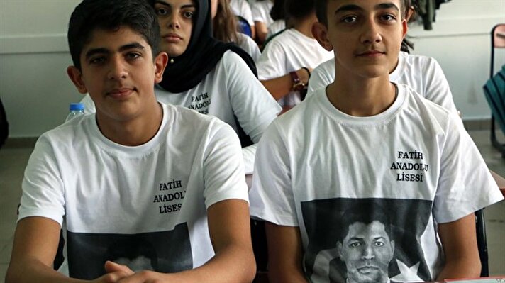 طلابٌ أتراك في مرحلة الثّانوية يلبسون أرديةً عليها صورة الضابط الشهيد "عمر خالص دمير"