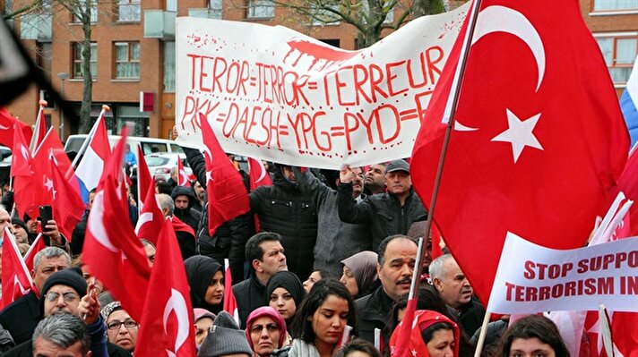 Türk toplumunun yoğun olduğu bölgesinde bulunan Afrikaanderplein Meydanı'nda, "Teröre Lanet, Demokrasiye Davet" adı altında gerçekleştirilen gösteriye yağmur ve fırtınaya rağmen çok sayıda kişi katıldı.