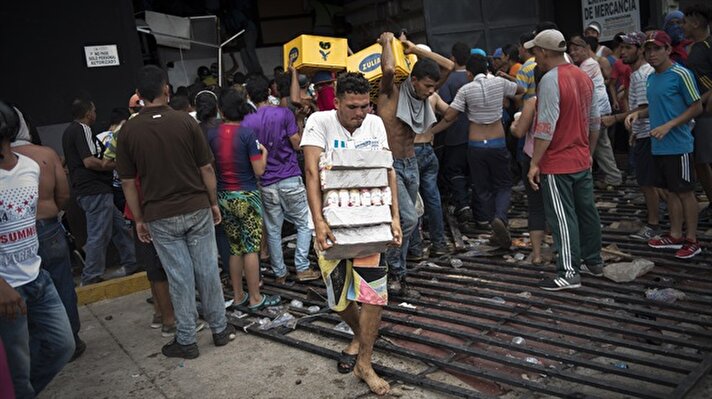 Venezuela'da halk sokakta: Kolilerce yiyecek yağmaladılar
