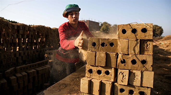 Mısır'ın Feyyum kentindeki ilkel bir tuğla atölyesinde kavurucu güneşin altında, zor şartlarda çalışan işçiler, ekmeklerini adeta taştan çıkarıyor.
