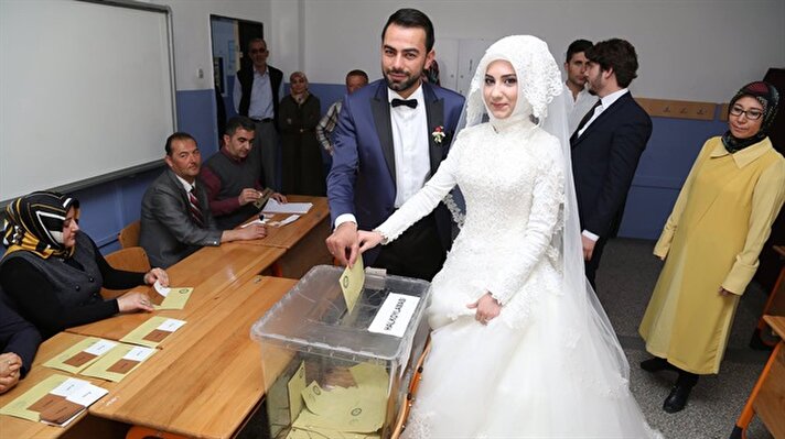 عروسان تركيان يدليان بصوتيهما في الاستفتاء على التعديلات الدستورية قبل حفل زفافهما في ولاية تشوروم