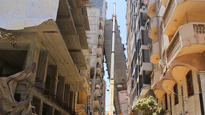 Mısır'ın İskenderiye kentinde 12 katlı bir bina temellerinden ayrılarak yan yattı. Yandaki diğer bir apartmanın üzerine devrilen bina için iş makineleriyle çalışma başlatıldı.​