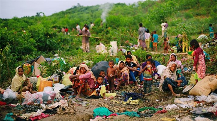 Rohingya refugees wait under open sky, pending the arrival of tent supplies in Teknaf, Bangladesh. 