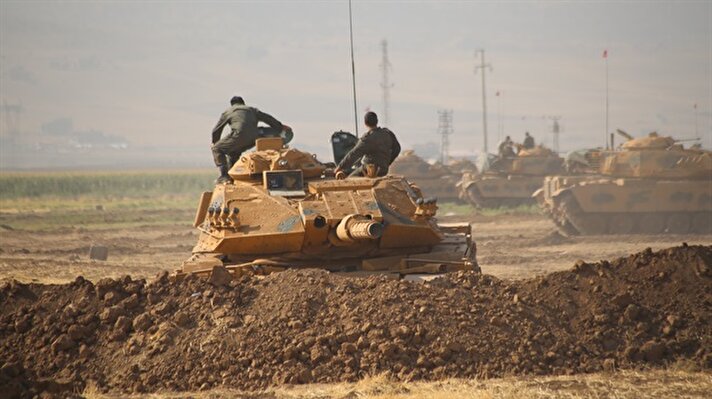 Tankların sürekli manevra yaptığı alanda iş makineleriyle kazılan mevzilere yerleştirilen zırhlı araçlarda askerler, teyakkuz halinde bekliyor.