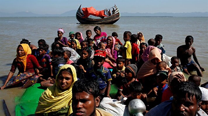 Rohingya refugees walk on the shore as they arrive on a makeshift boat after crossing the Bangladesh-Myanmar border, at Shah Porir Dwip near Cox's Bazar.