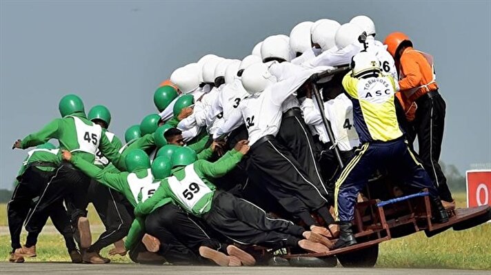 “Tornadoes," the motorcycle display team of the Indian army, fall as they attempt to break a world record for most men on a single moving motorcycle at the Yelahanka Air Force Station in Bengaluru, India.


