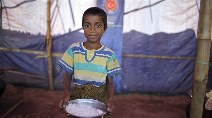 Rohingya children help distribute food aid at refugee camp