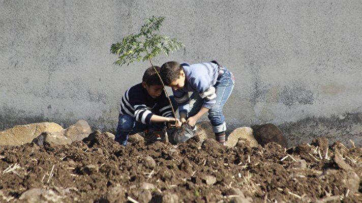 Syrian kids plant trees during the event named 'We plant future' in the towns besieged by Assad Regime in Homs, Syria on January 3, 2018.​